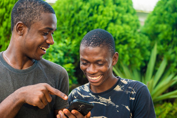 young african man showing a friend something on his phone