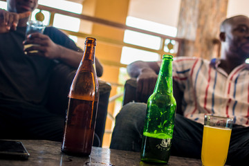 young african men sitting at a local bar drinking beer