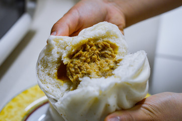 Hands Open White Chinese Steamed Bun Showing Meat Veggies Filling Inside