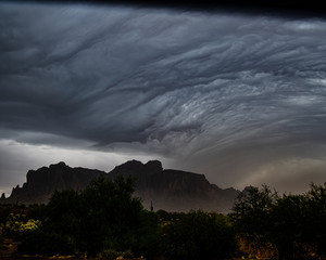 storm clouds rolling over the Superstition Mountains and kicking up a dust storm.