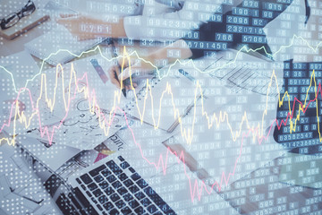 A woman hands writing information about stock market in notepad. Forex chart holograms in front. Concept of research. Double exposure