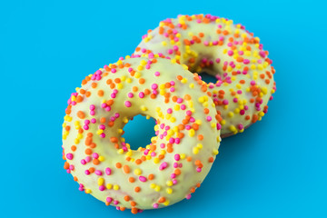 Glazed donuts on blue background. Round donut with a hole. Funny mood concept. Modern food design.