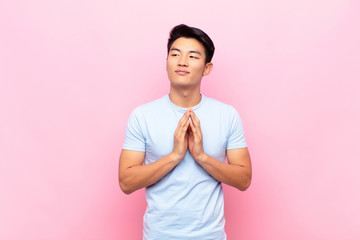 young chinese man feeling proud, mischievous and arrogant while scheming an evil plan or thinking...