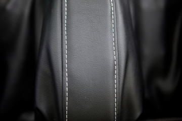 Modern luxury car leather interior. Part of leather car seat details with white stitching. Interior of prestige car. Perforated leather seats. Perforated leather. Car detailing. Black and white