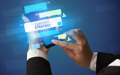 Female hand typing on smartphone with CONTENT STRATEGY inscription, social networking concept