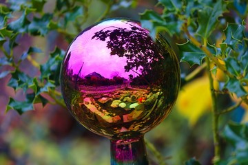 Bunte Glaskugel mit Spiegelung als Gartendekoration