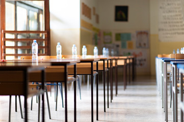 Exam examination room or hall set up ready for students to sit test. multiple desks tables and chairs. Education, school, student life concept.