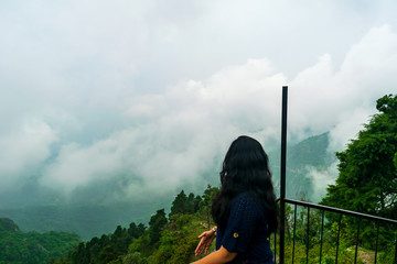 A woman enjoying the view of the low lying monsoon clouds, Mussoorie, Uttarakhand, India © Sondipon