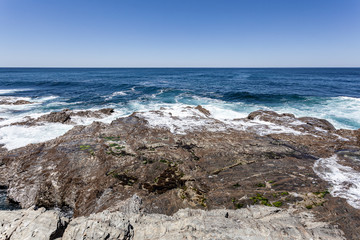 Rebentação das ondas do oceano no rochedo da costa.