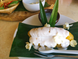 Thai style Banana in syrup with coconut milk on green banana leaf , sweet dessert in Thailand