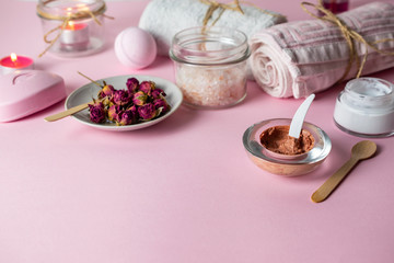 Obraz na płótnie Canvas Homemade scrub and skin care with natural organic ingredients on pink background with towels, candles and soap