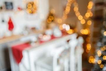 Beautiful holiday decorated kitchen with Christmas tree and bright lights , out of focus shot for photo background