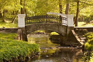 Old bridge over the river in Kaliningrad Central Park in early spring. Russia.The park was known as Luisenwahl while part of Konigsberg, Germany, until 1945 and was in English landscape garden style.