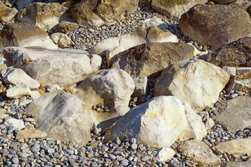 White and dark stones and pebbles on sunny day, natural background.