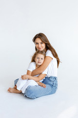 Happy mom and daughter cuddling on a white background. Happy family concept