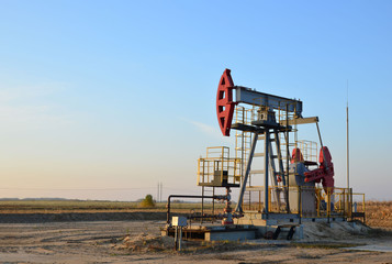 Fototapeta premium Oil drilling derricks at desert oilfield for fossil fuels output and crude oil production from the ground. Oil drill rig and pump jack. 