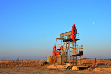 Oil drilling derricks at desert oilfield for fossil fuels output and crude oil production from the ground. Oil drill rig and pump jack. 