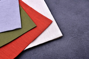 Fototapeta premium Multicolored linen towels on a dark stone background.