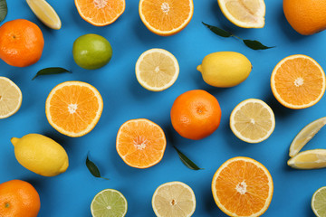 Flat lay composition with tangerines and different citrus fruits on blue background