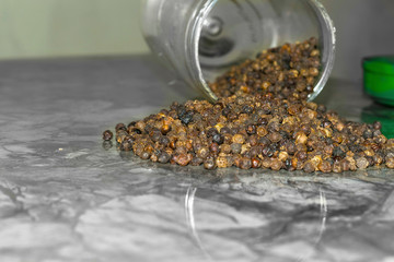 lots of fresh and healthy black pepper out of a crystal bottle spread on table 