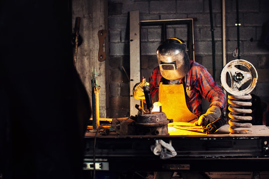 Metal worker wearing welding mask while working