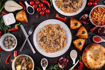 The concept of Eastern asian festive cuisine. Assorted Uzbek food set, pilaf, samsa, lagman, manti, shurpa restaurant concept Eastern arabic new year and Christmas dish from lamb served cookware.