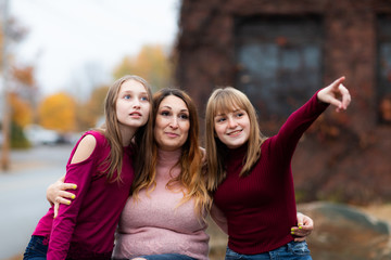 Teenager girls, Daughters and Mother smiling and hug together. Adorable Affection Casual Life Concept. showing something by hand