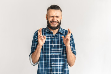 Adult bearded man crossed fingers on hands