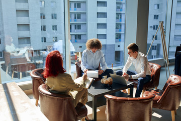 A trading company business meeting with a client, two caucasian men and a woman discussing their...