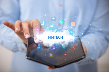 Businessman holding a foldable smartphone with FINTECH inscription, technology concept