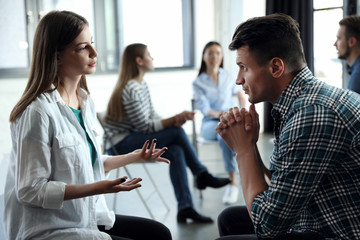 Psychotherapist working with patient in group therapy session indoors