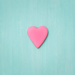Cookies covered with pink icing on a turquoise background. Holiday concept