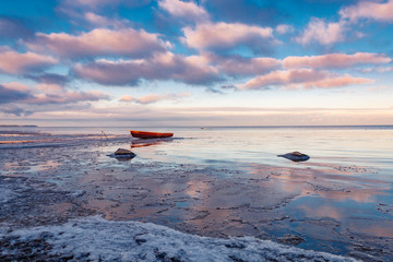 Stunning winter sunset on the frozen Peipsi lake near the fishers Nina village in Estonia, the old...