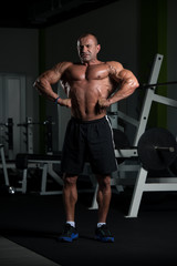Obraz na płótnie Canvas Mature Bodybuilder Posing Biceps After Exercises