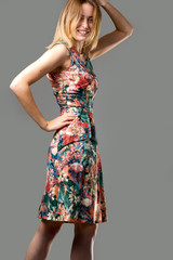 shot of a young girl a light background who jumps in a colorful dress with flying hair