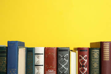 Collection of old books on yellow background, space for text