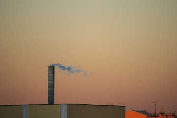 Smokestack against the sunset sky. Pollution of nature and the ozone layer, a symbol of ecology.