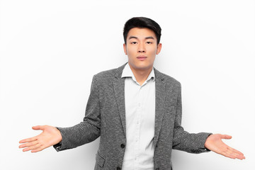 young chinese man feeling puzzled and confused, unsure about the correct answer or decision, trying...