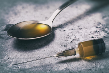 The drug is the enemy of the modern world. Drugs in a syringe and spoon on the table, close-up