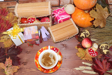 Cappuccino in a cup, Thanksgiving, autumn background with seasonal autumn nature berries, pumpkins, apples and gifts on a wooden background, copy space, happy thanksgiving concept,