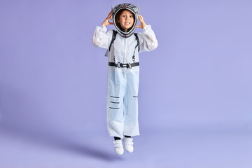 Portrait of child boy in protective white suit while jumping up isolated over purple background - Powered by Adobe