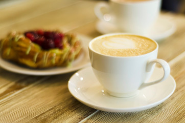 morning hot coffee cappuccino, mocha, latte with lush milk or creamy whipped foam and pattern. breakfast with a bun, pastries with berries and drink in white cup. copy space, banner, text