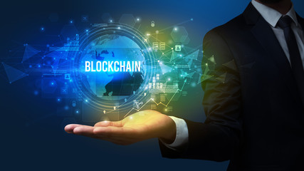 Elegant hand holding BLOCKCHAIN inscription, digital technology concept