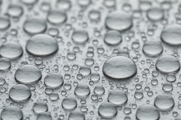 Water drops on grey background, closeup view