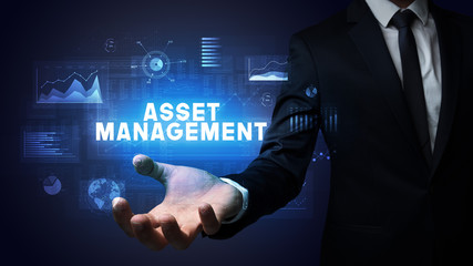 Hand of Businessman holding ASSET MANAGEMENT inscription, business success concept