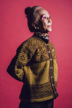 影になっている、柄模様のセーターを着たシニア女性のポートレート