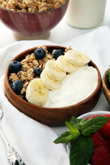 Tasty homemade granola served on table. Healthy breakfast with a bowl of oatmeal with banana, blueberries, strawberries and healthy food for Breakfast