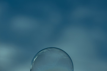 Soap Bubble against a cloudy sky backdrop landscape