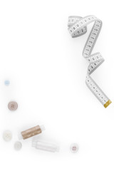 vertical design composition of colored threads, a set of buttons and a curved measuring tape with copy space for text on a white background