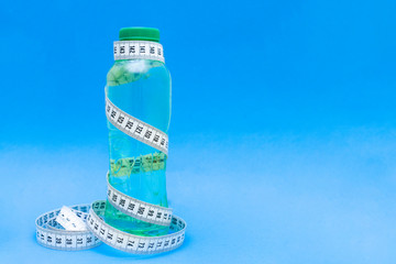 Bottle of water with measuring tape. Symbol of healthy diet.